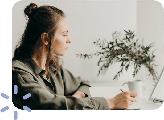 Femme prenant des notes devant un écran