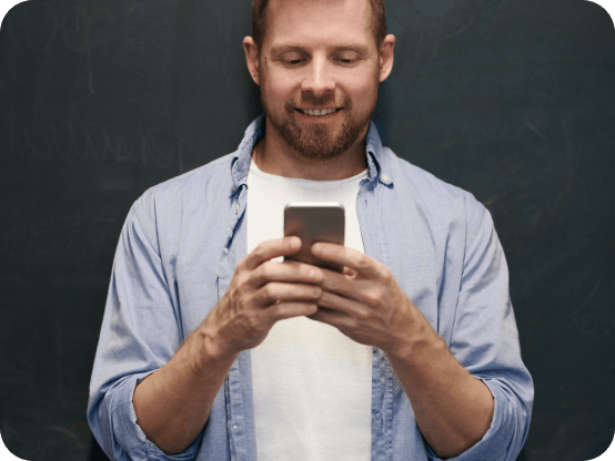 Homme souriant devant son téléphone, en train de répondre à un questionnaire