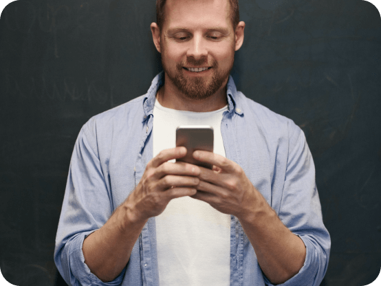 Homme souriant devant son téléphone